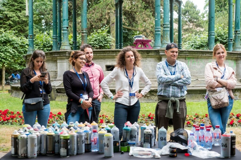 Groep mensen staat te luisteren naar instructeur die teambuildingactiviteit uitlegt